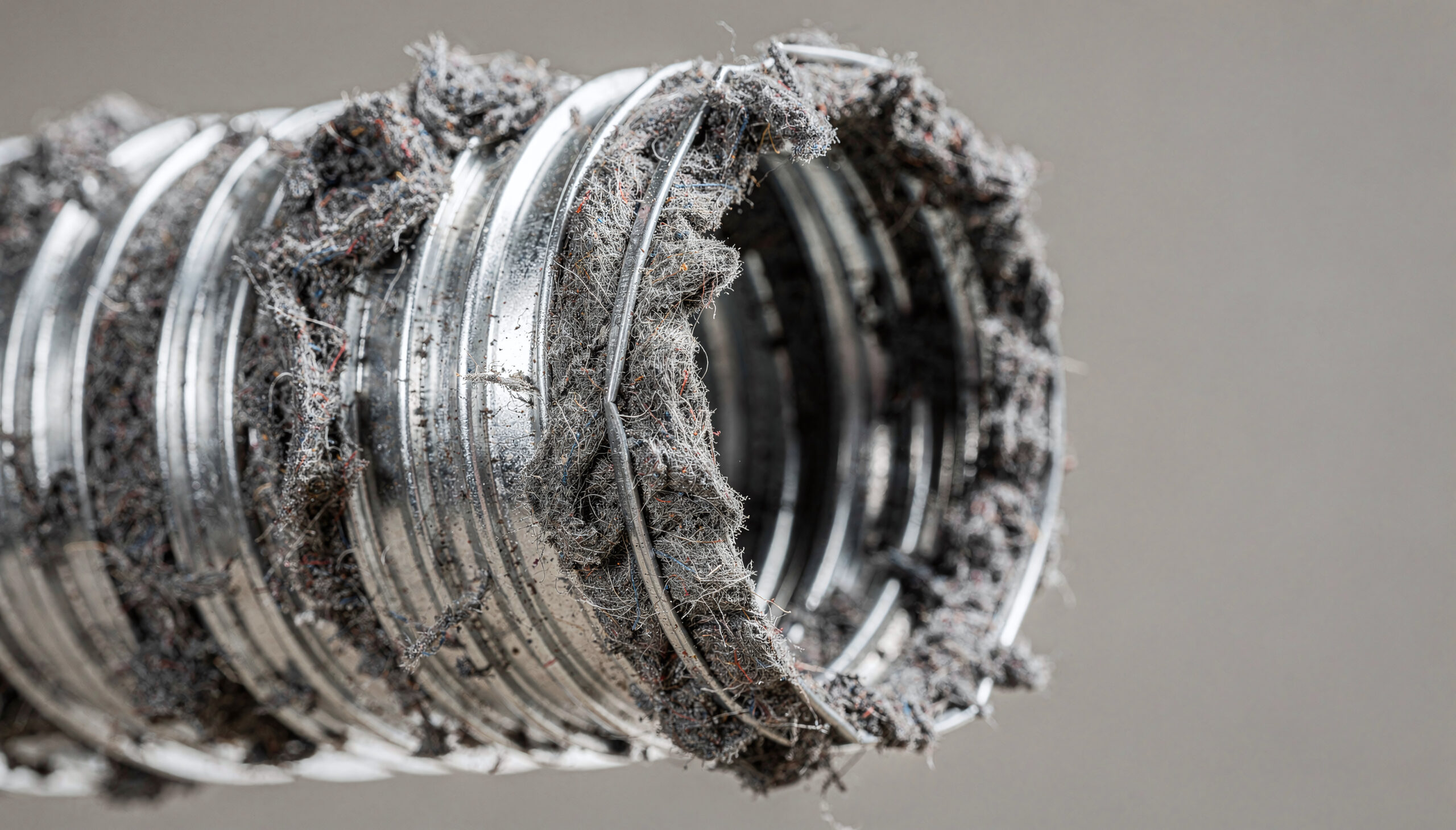 Recurring House Cleaning vs. One-Time Deep Clean: Which Is Right for Your Family? 7 Close-up of a severely clogged dryer vent hose, filled with thick, matted lint and dust, highlighting maintenance needs for home safety and efficiency
